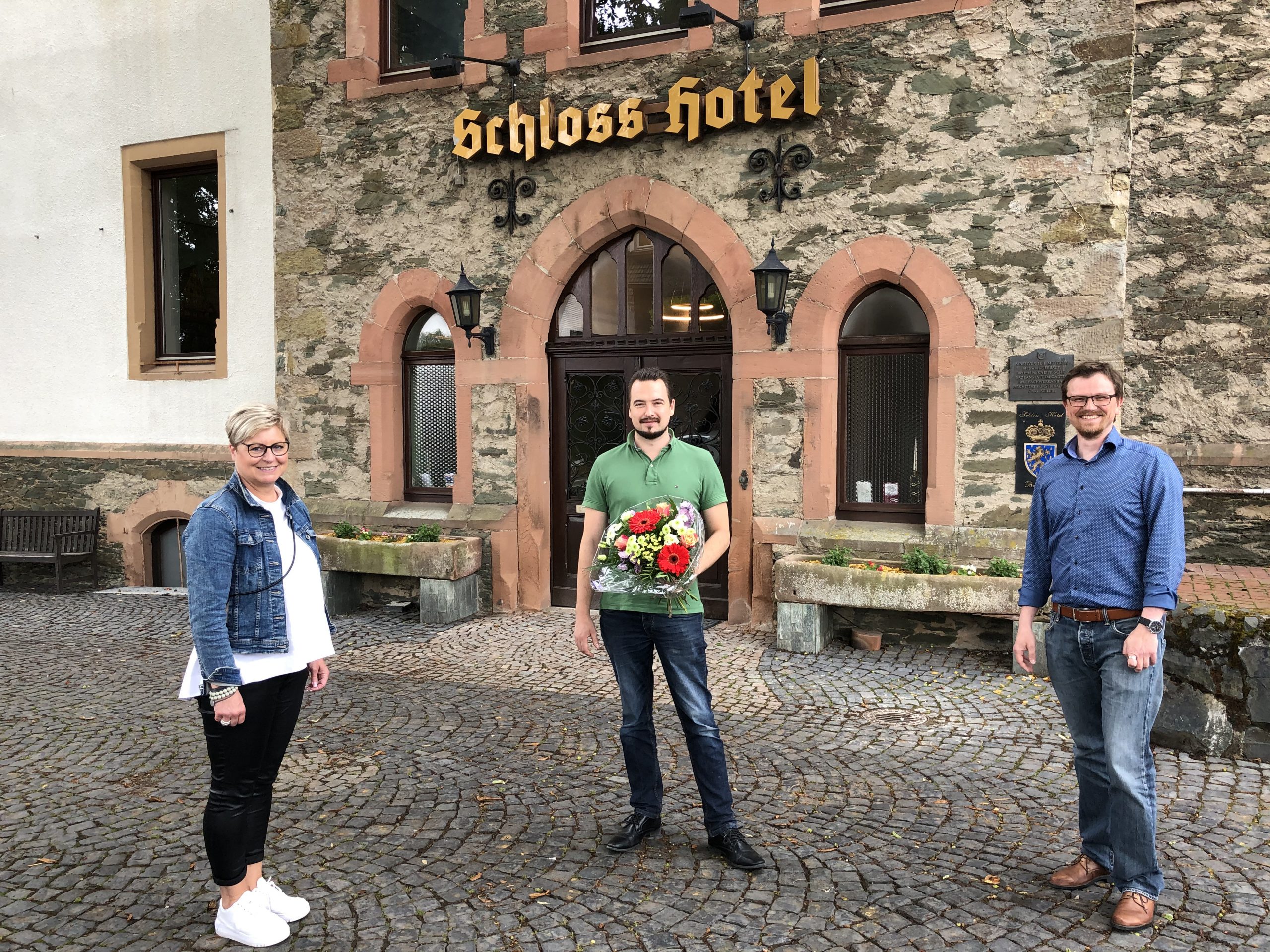 Regina Andermann  und Philipp Borchardt gratulieren Lieblingsplatz-Gastgeber Malte Malessa (Mitte) zur Neueröffnung des Schloss-Hotels in Braunfels